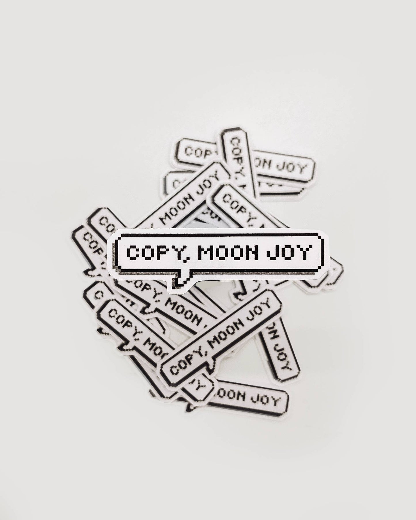 Multiple 'COPY. MOON JOY' stickers scattered on a light gray background