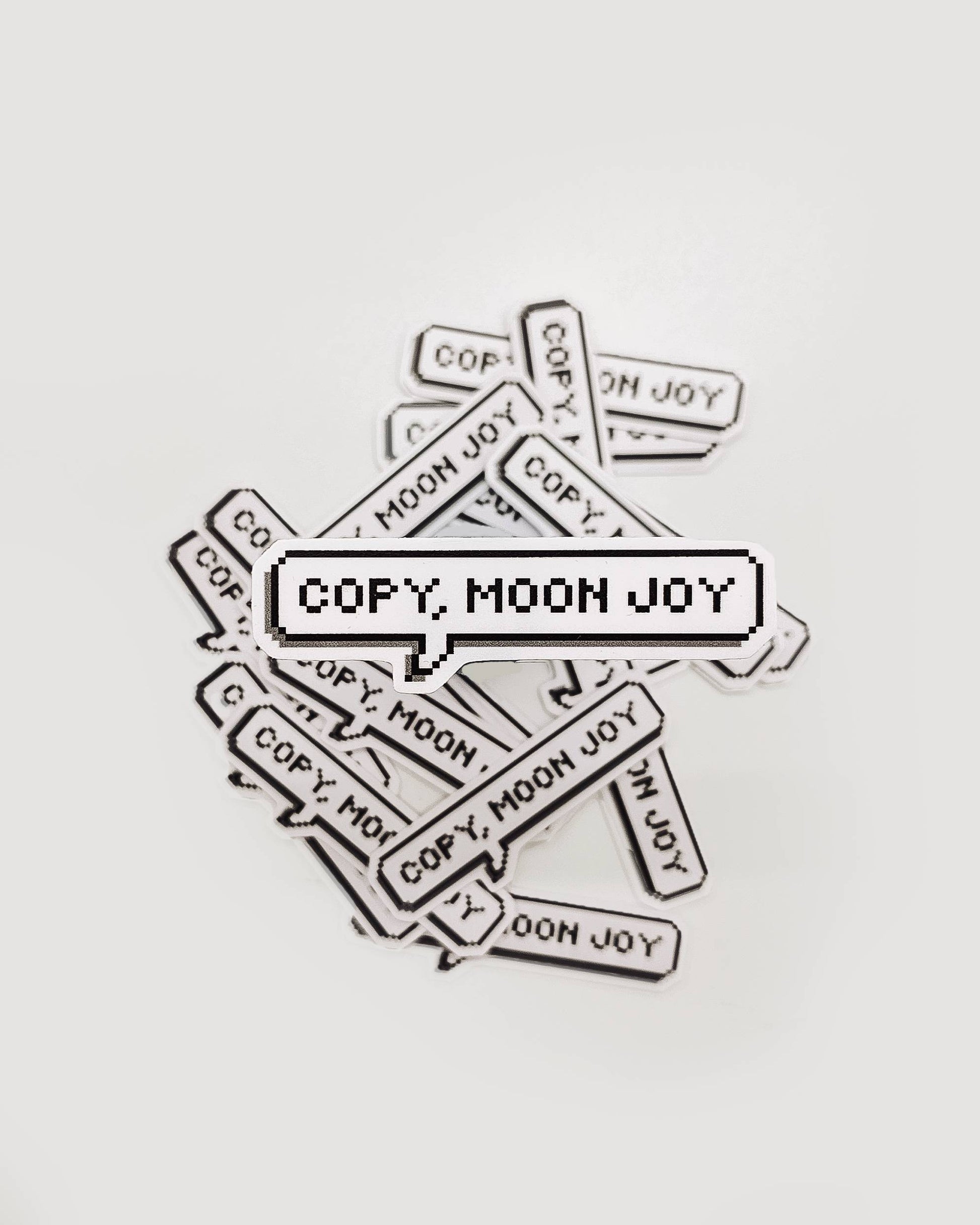 Multiple 'COPY. MOON JOY' stickers scattered on a light gray background
